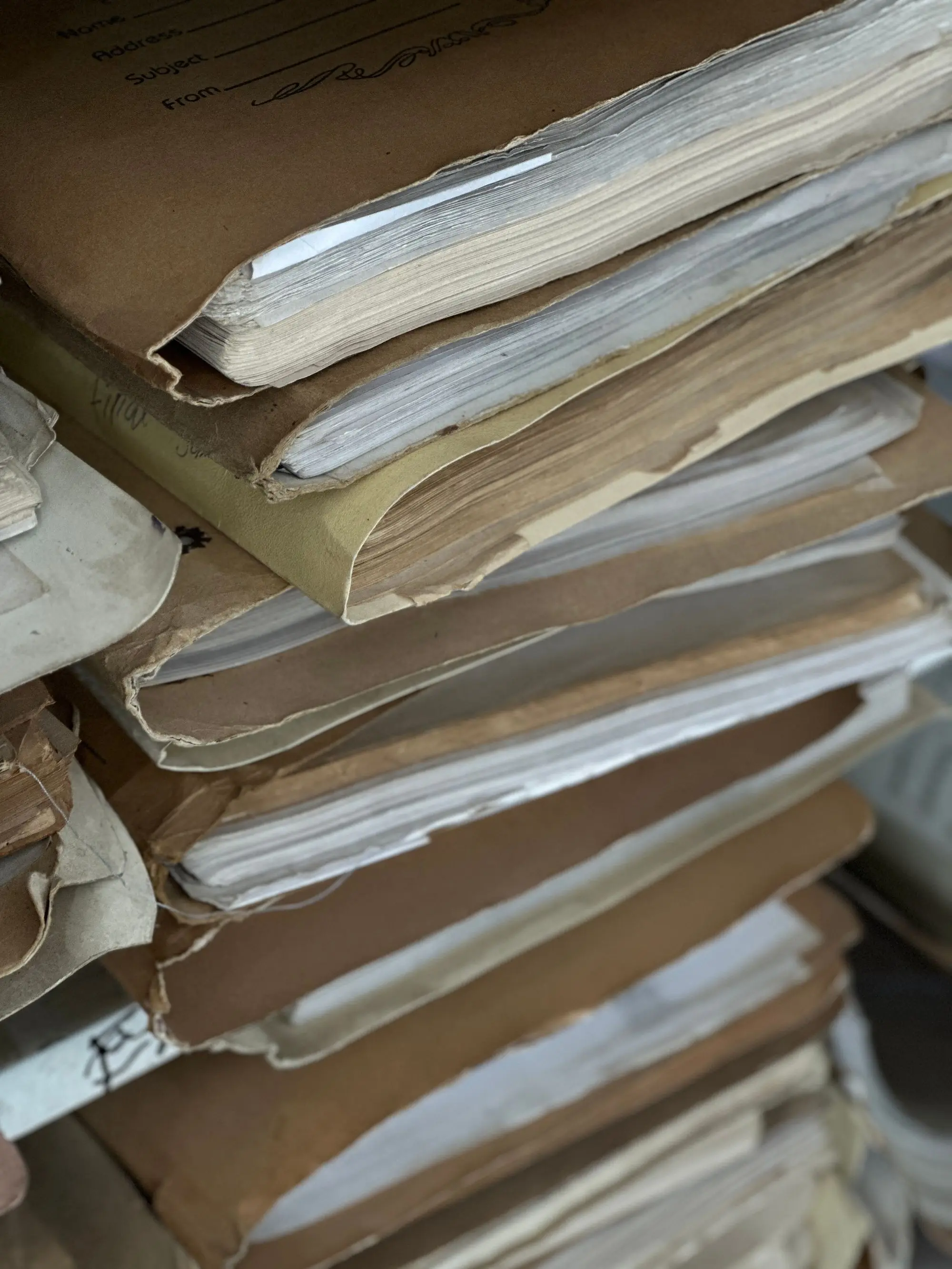 Decades-old case files stacked in brown folders