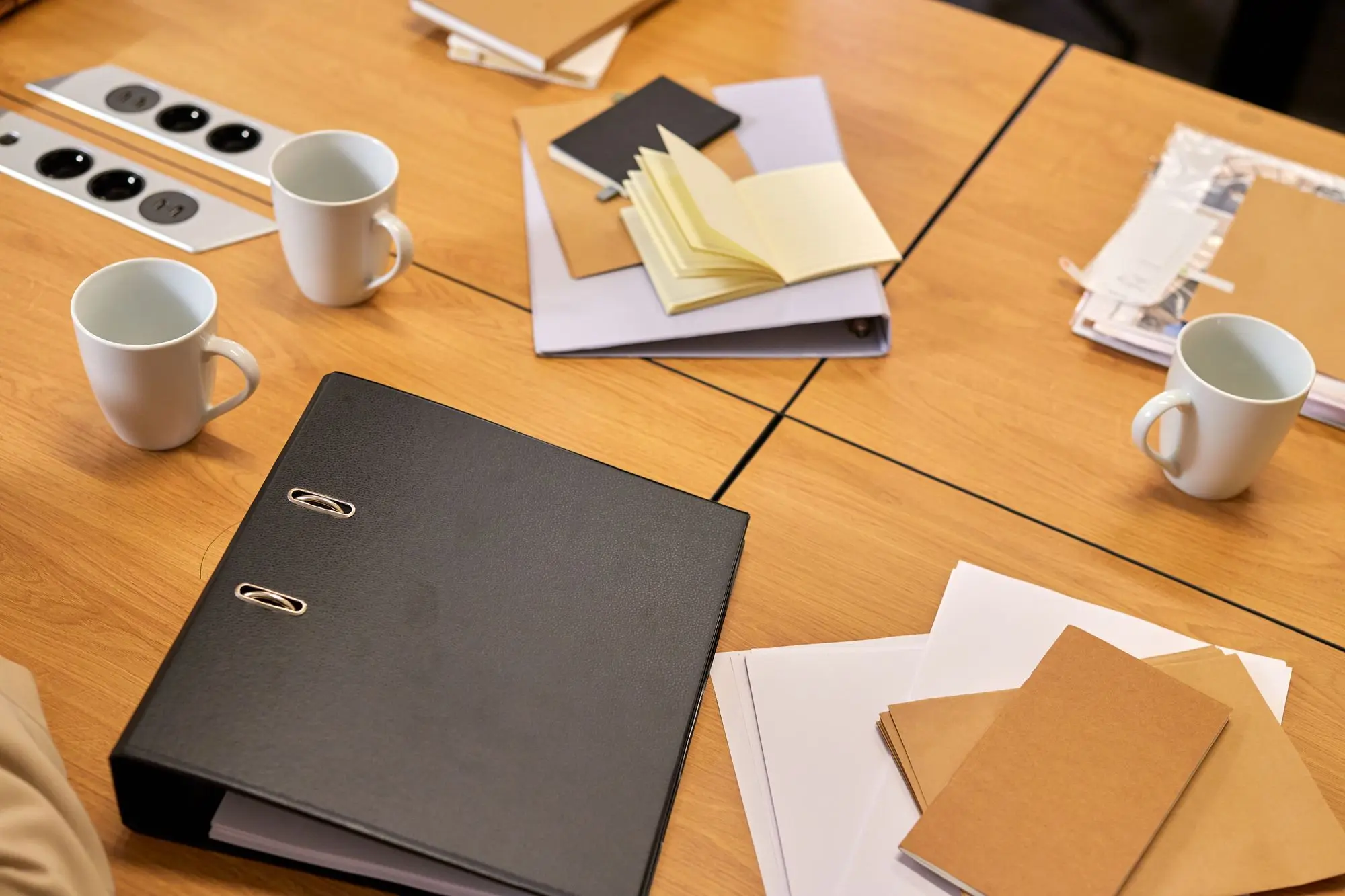 A tidy desk with binders, papers and coffee