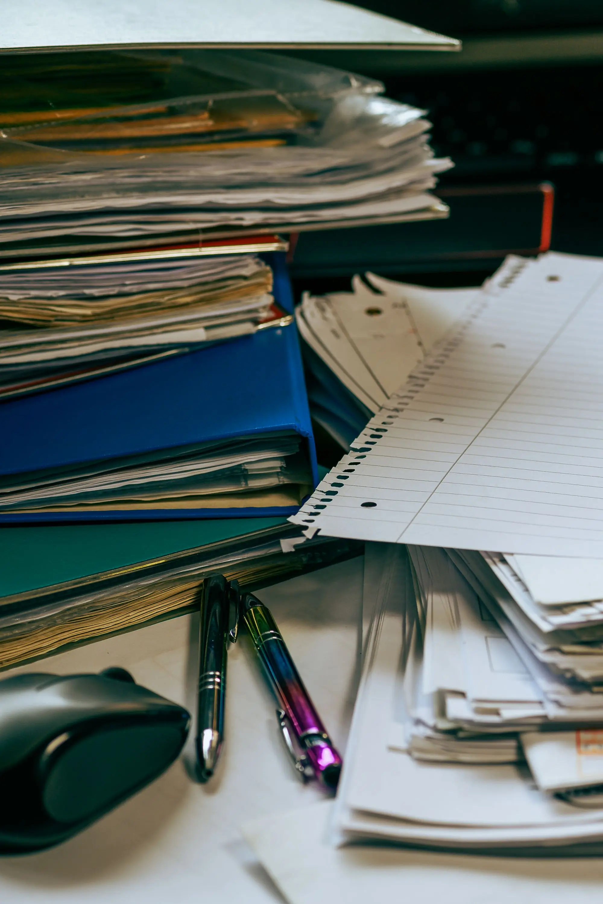 A desk covered in stacks of papers and folders