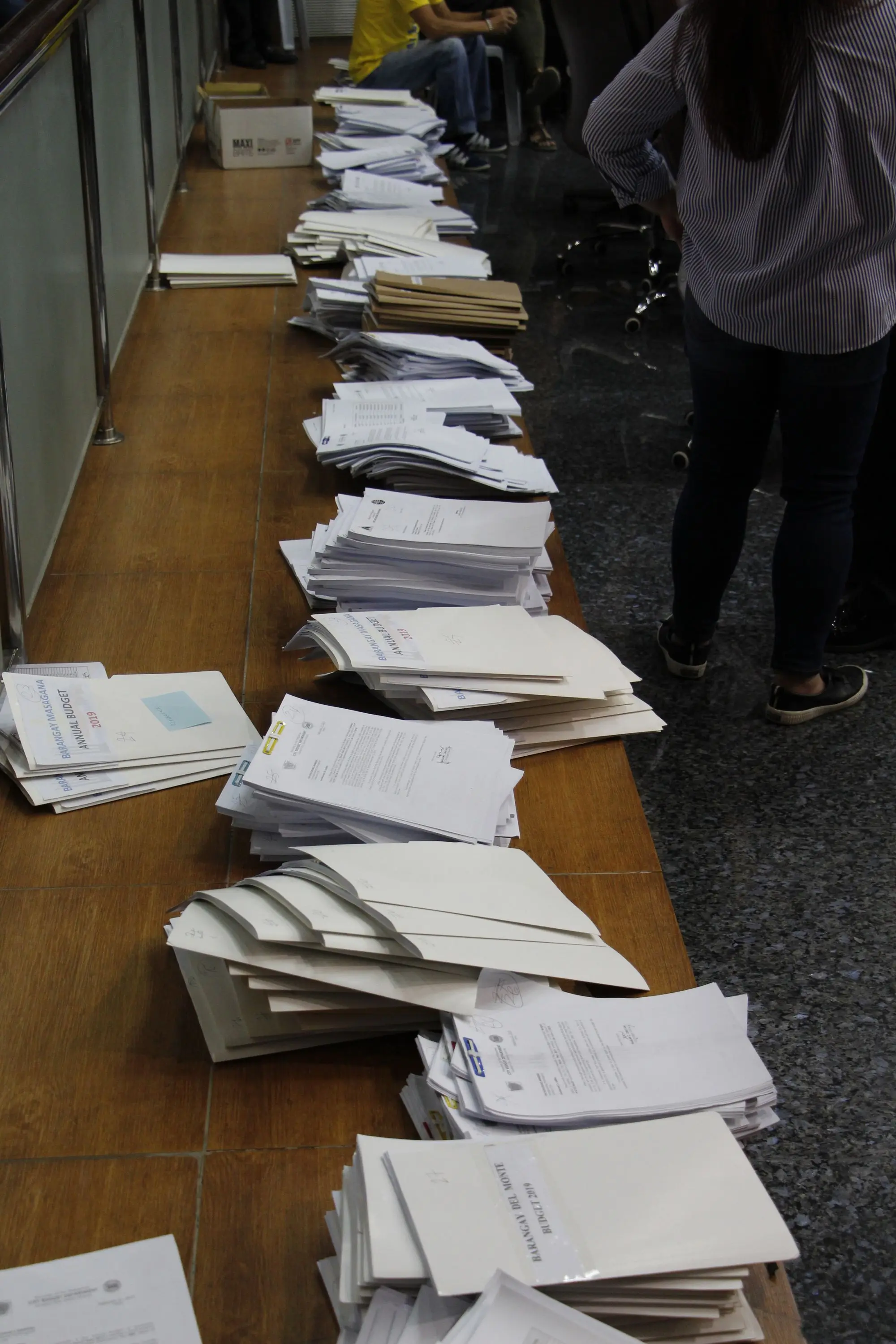 Stacks of documents on a wooden desk