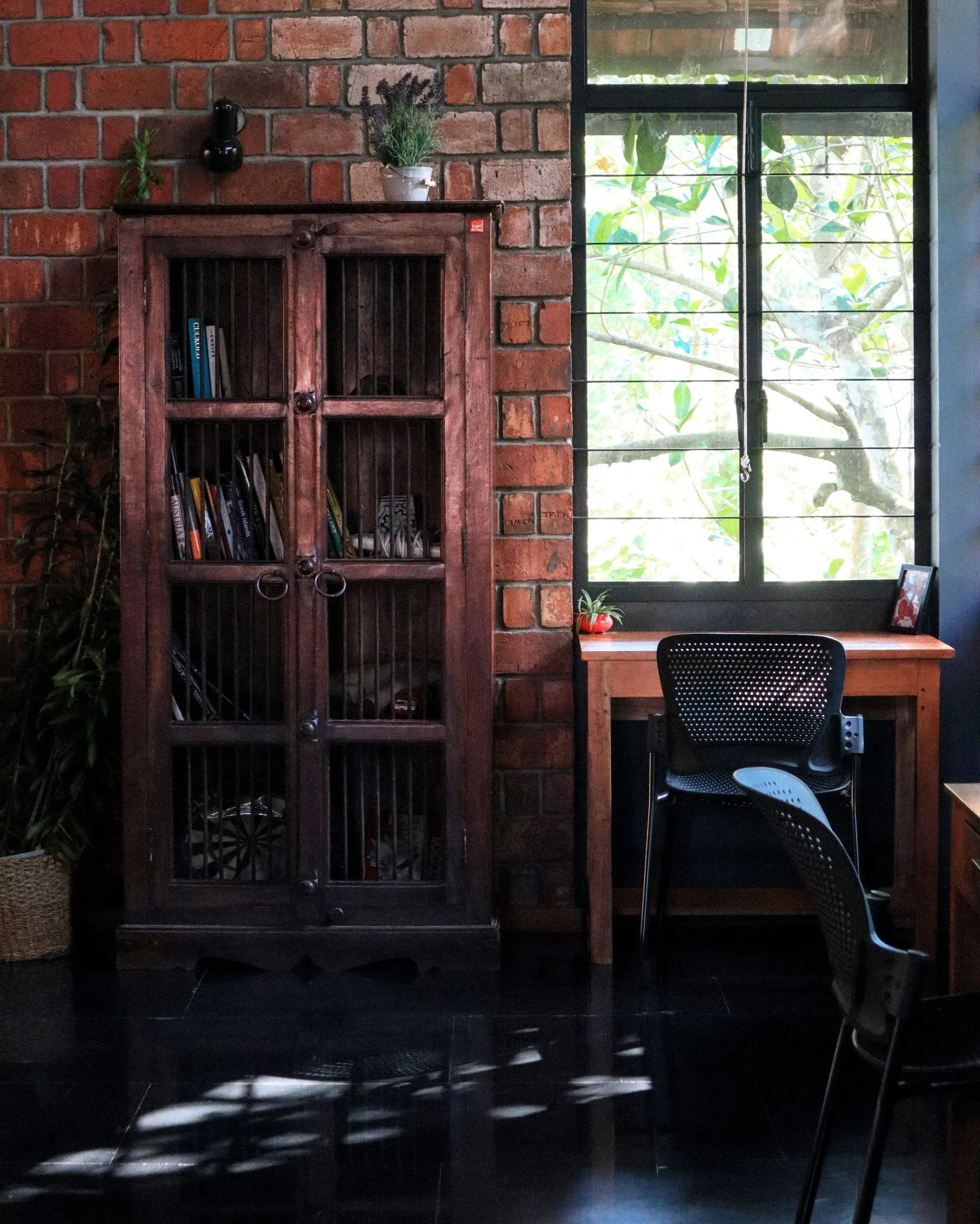 A sunlit office with a bookcase, a desk and a window